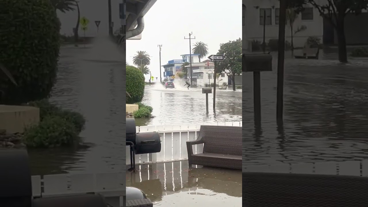 man surfs behind car after heavy