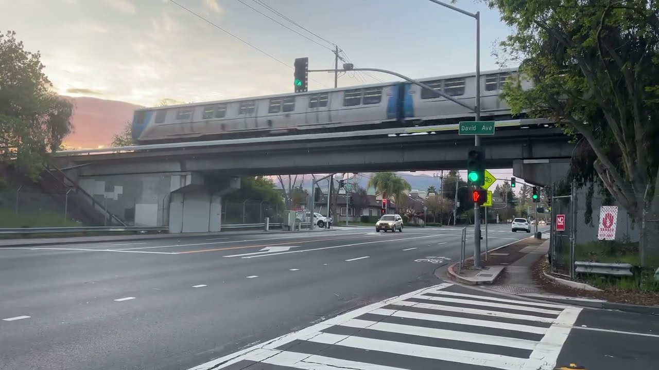 Incoming 8 car YL SFO airport train passing by oak grove road with the sunrise in the background 2 incoming 8 car yl sfo airport tr 1