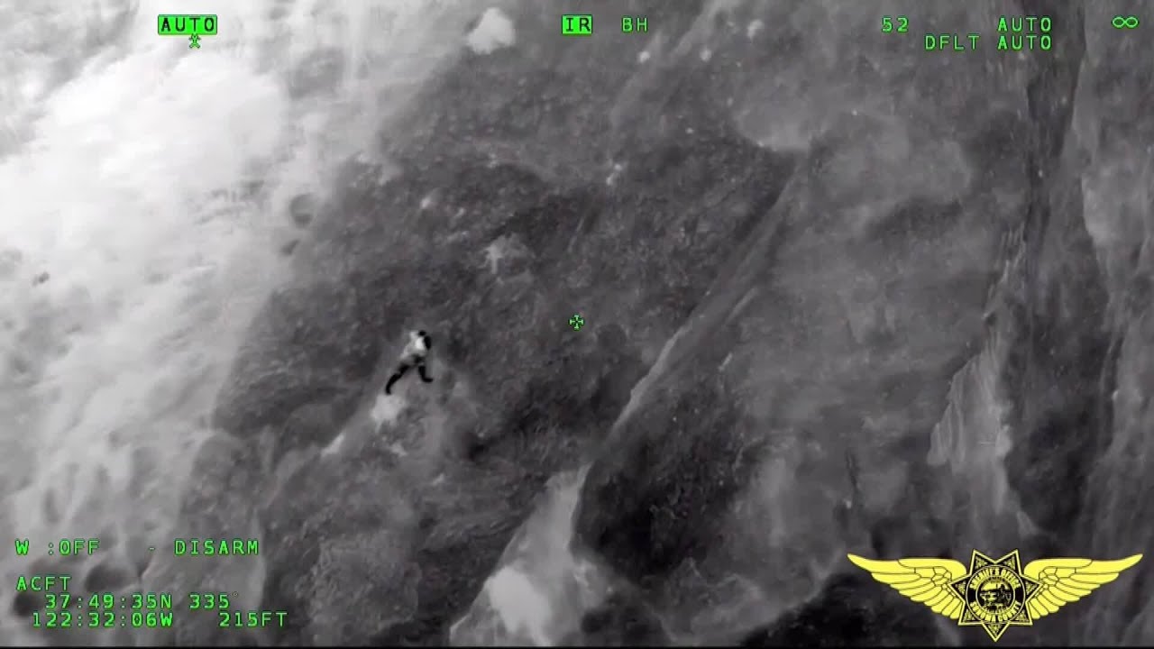 watch man clinging to cliff at g